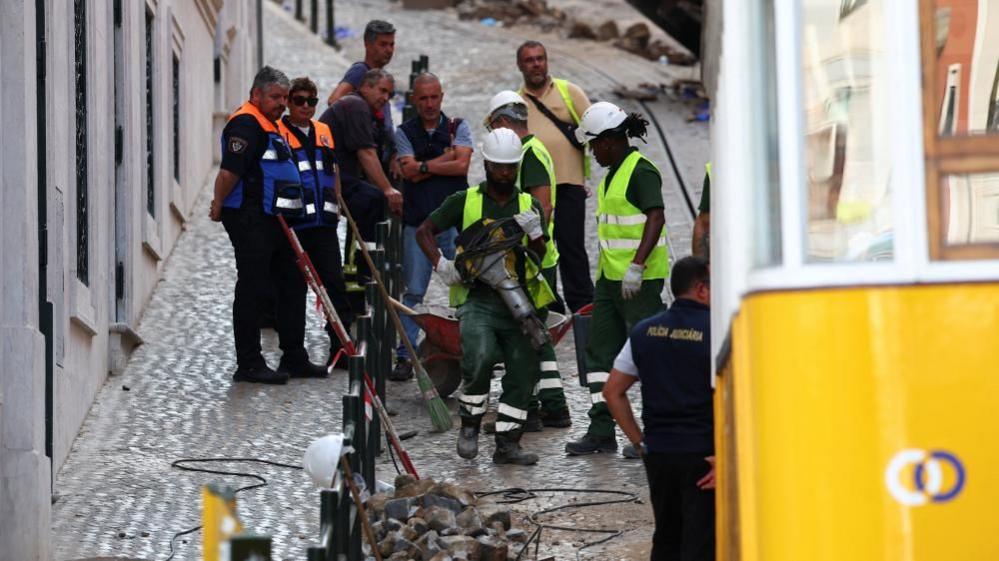 Rescue workers assessing funicular after crash in Lisbon