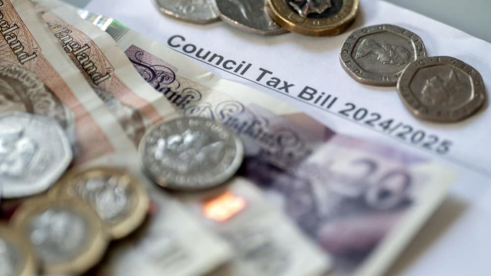Money stacked on top of a council tax bill.