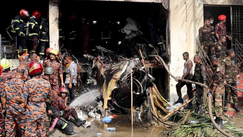 Firefighters and army members work next to the wreckage of an air force training aircraft