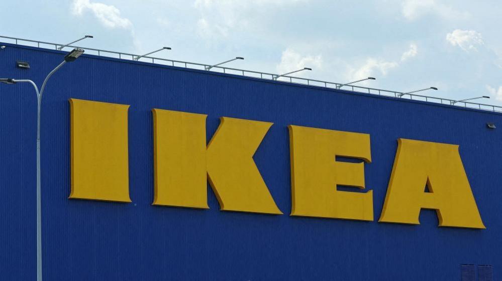 A blue building with large yellow writing on it. The writing reads: "IKEA".