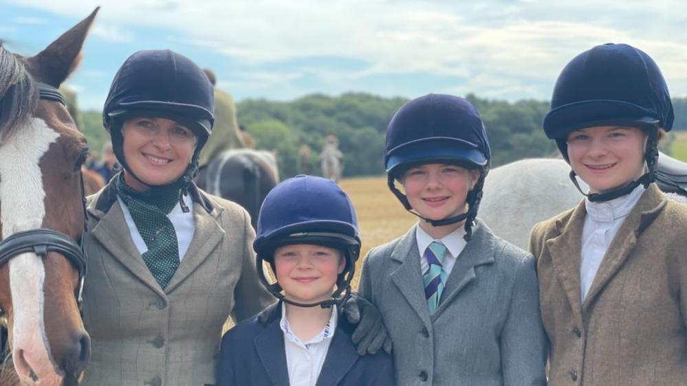 Horse, mum Julia, Gilbert, 9, Lila, 12, and Amelia, 15, all in helmets and riding gear