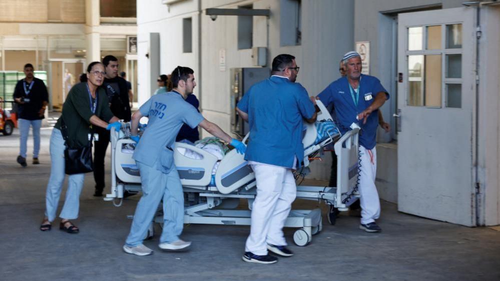 Medical staff transporting a patient on a stretcher at the Soroka Medical Center.