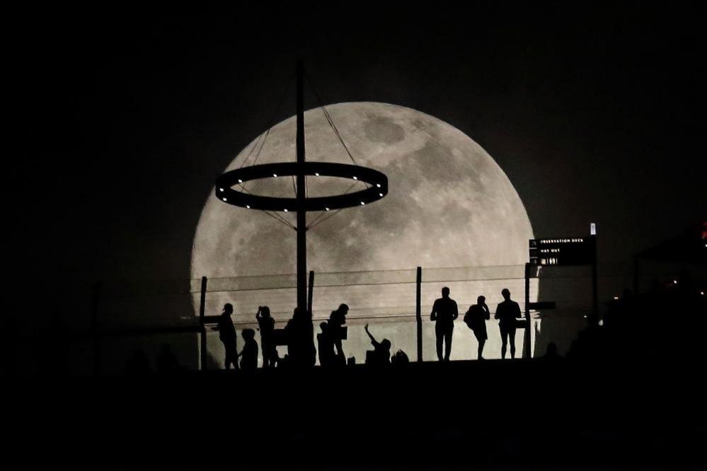 The moon rises behind the Marina Bay Sands in Singapore