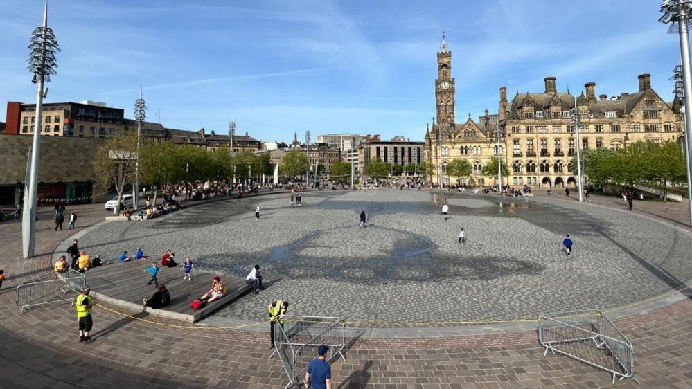 An empty water feature, a paved area in a city centre.