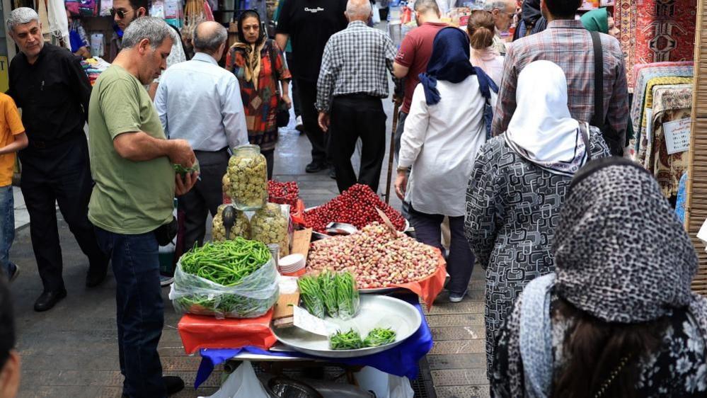 People walking through a market place in Tehran (file photo)