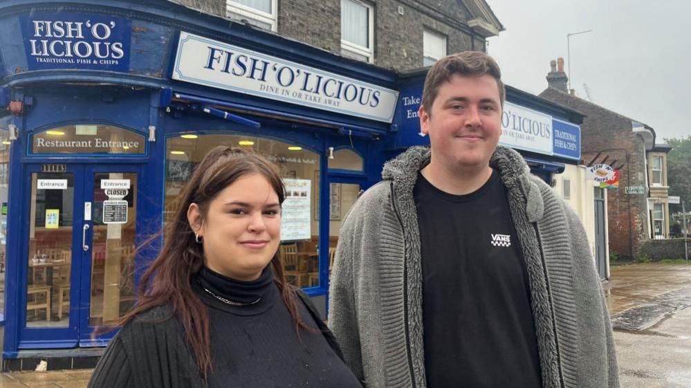 Tom Howes and Dory Czicza standing outside the Fish'o'licious restaurant where they work