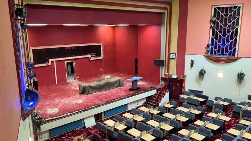 A disused stage and bingo seats in an Art Deco theatre