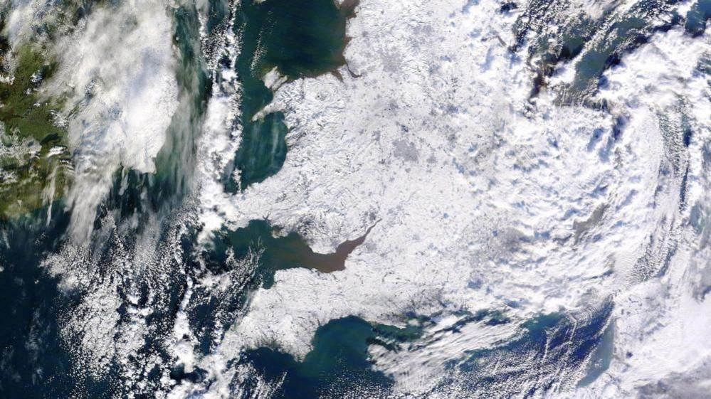 A colour image taken by satellite, looking at England and Wales from about Cumbria southwards. The entire visible landscape is white from extensive earlier snow, now gleaming under largely clear skies. The photo was taken in early January 2010, just after the last widespread white Christmas nationally.