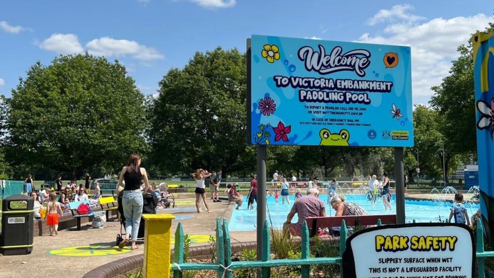 The entrance to the Victoria Embankment Paddling Pool, with children splashing in the background.