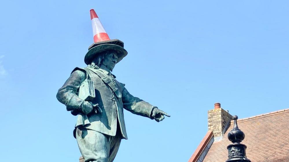 Cromwell statue with roof in background