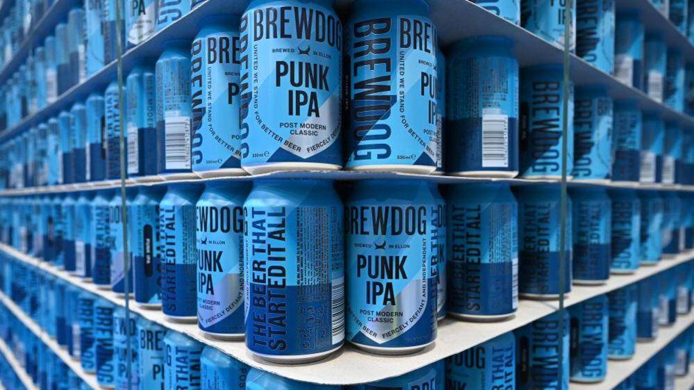 Shelves full of cans of Brewdog's Punk IPA beer. The cans are two shades of blue.
