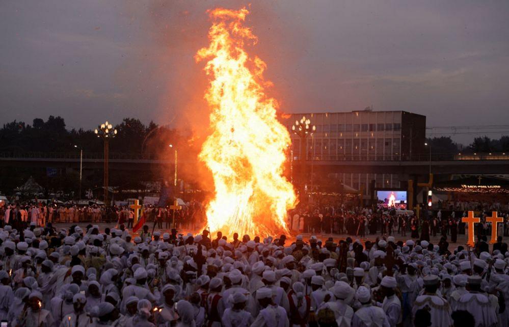 Ethiopian Orthodox faithful stand next to a bonfire during the Meskel festival,