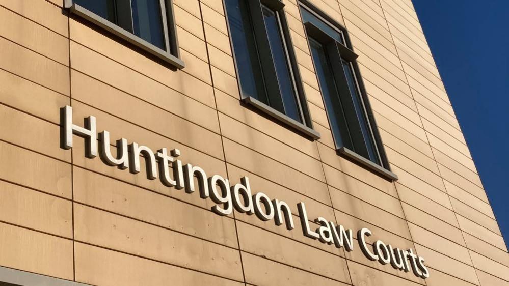 A sign for Huntingdon Law Courts on the side of a light-brown building