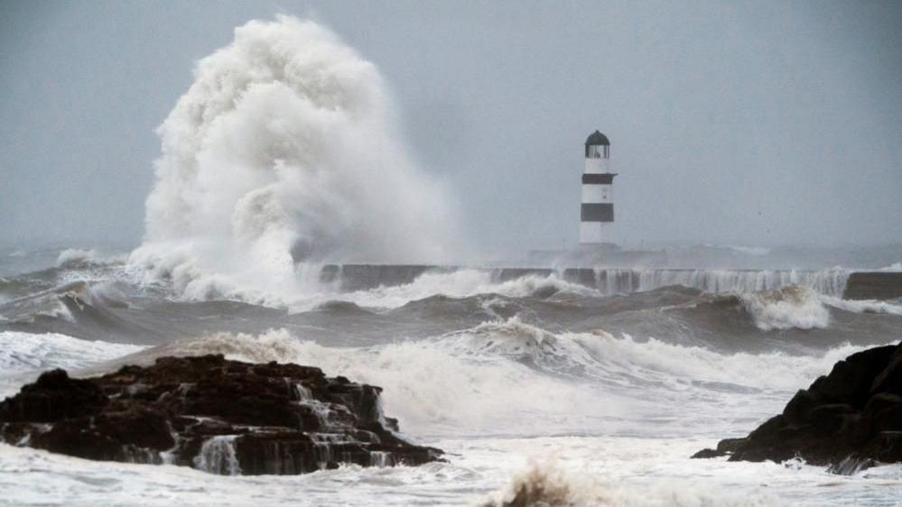 Waves crash against the lighthouse in Seaham Harbour, County Durham.