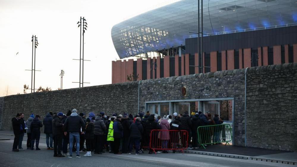 Fans queue to get into the new stadium.