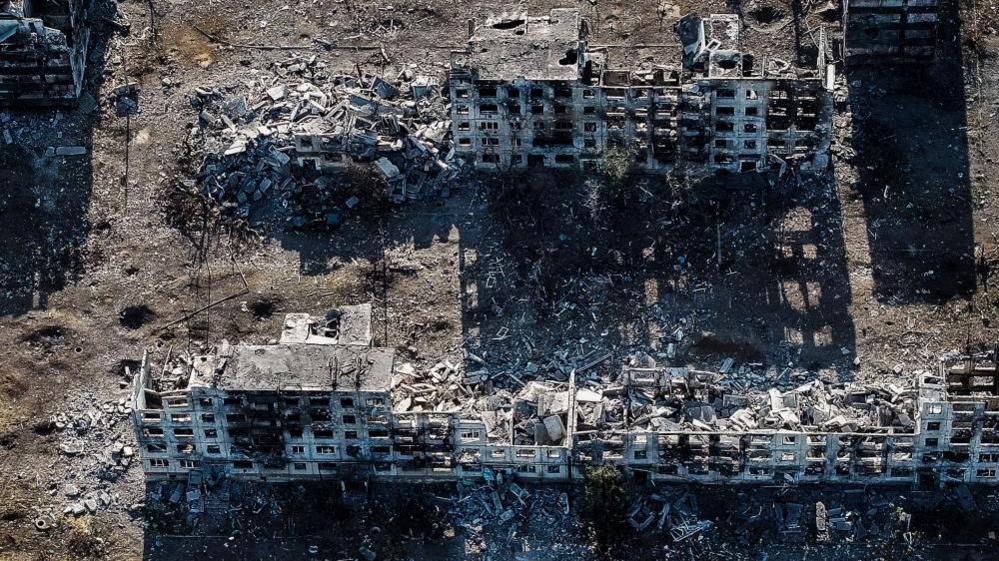 An aerial shot shows the skeletal ruins of apartment blocks in the Donetsk town of Chasiv Yar.