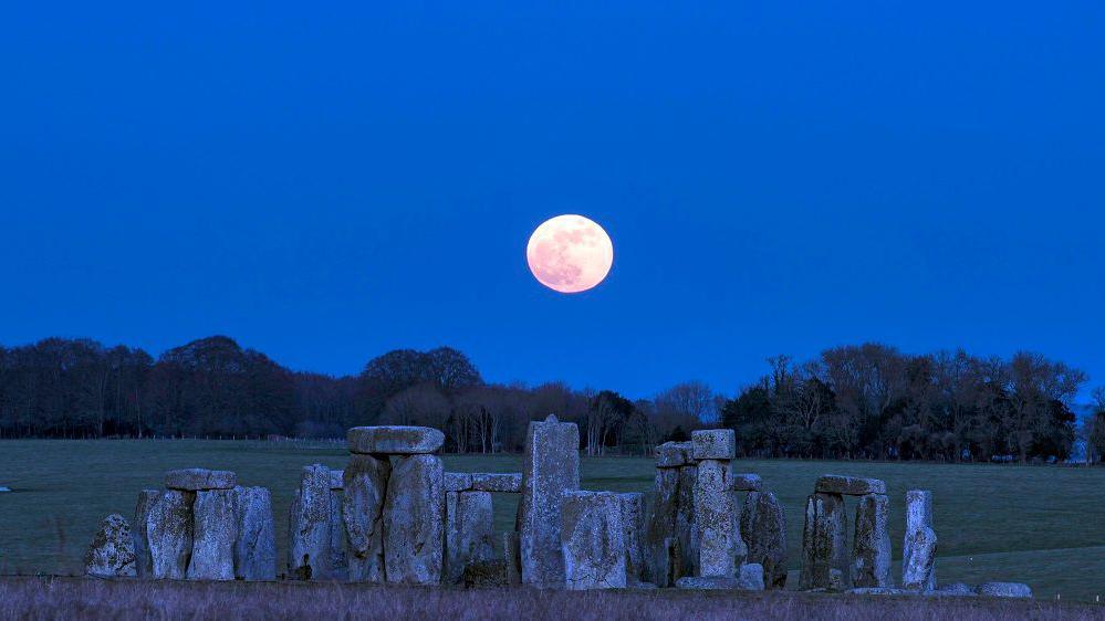 Stonehenge pictured with a full moon "floating" over it