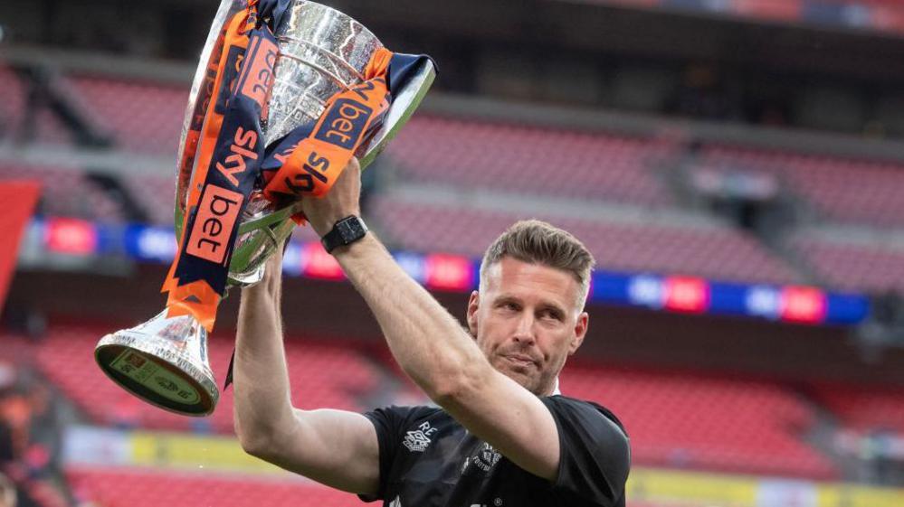 Rob Edwards lifts the Championship play-off trophy after their win over Coventry in 2023