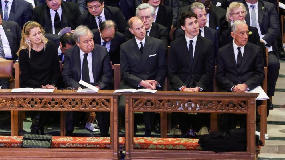 Justin Trudeau sitting alongside Prince Edward in a church pew at the National Cathedral for Jimmy Carter's funeral. 