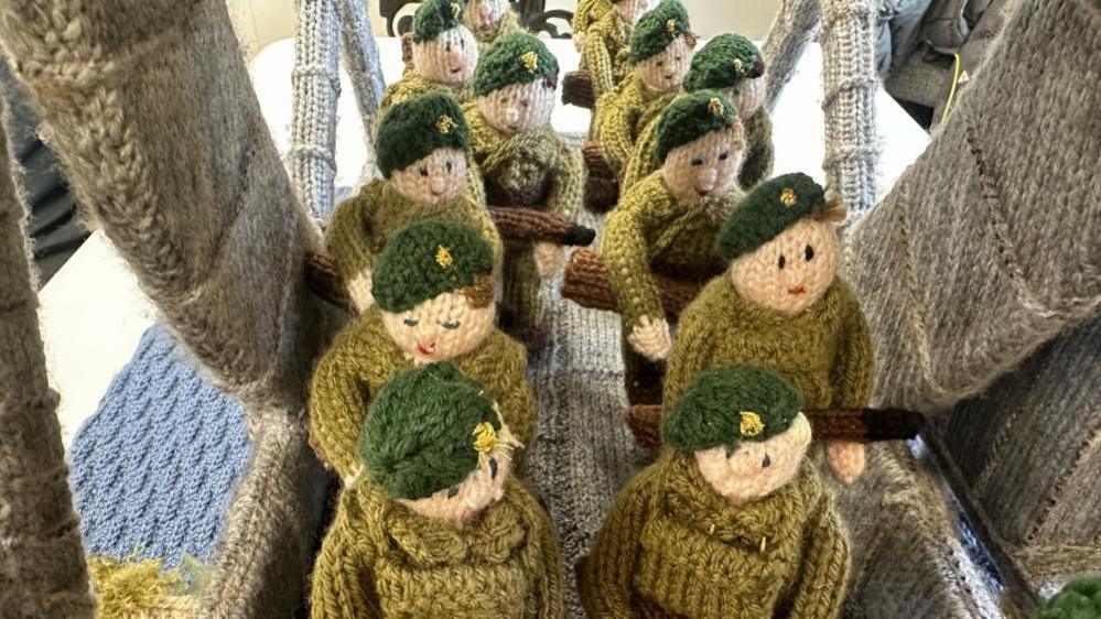 A closeup shot of the knitted soliders crossing the bridge