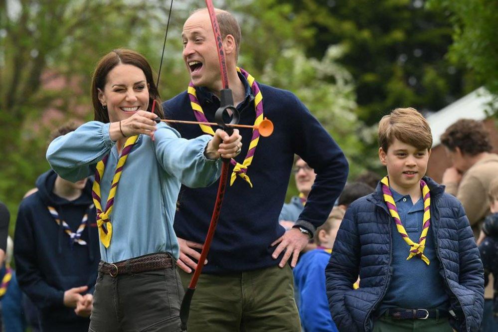 Watched by the Prince of Wales and their son Prince George, the Princess of Wales prepare to fire an arrow