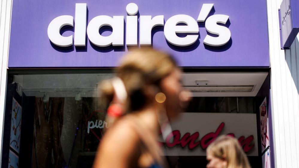 Claire's store front in focus with some blurry people in the foreground