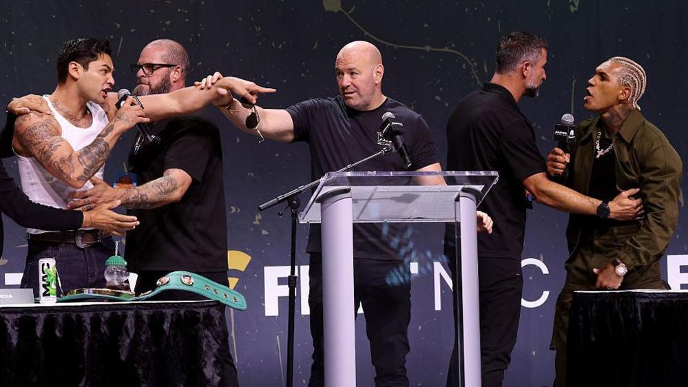 Ryan Garcia and Conor Benn shout at each other, with Dana White between them, at the Zuffa Boxing news conference on 18 July 2026