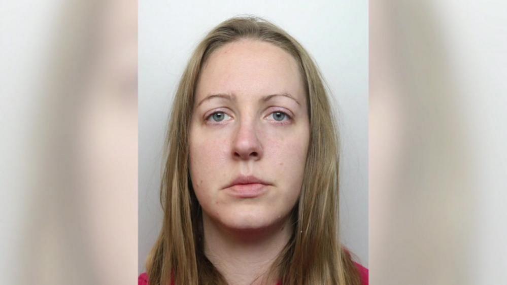 A mugshot of Lucy Letby - a young woman with long blond hair. She has a serious expression and is wearing a red shirt