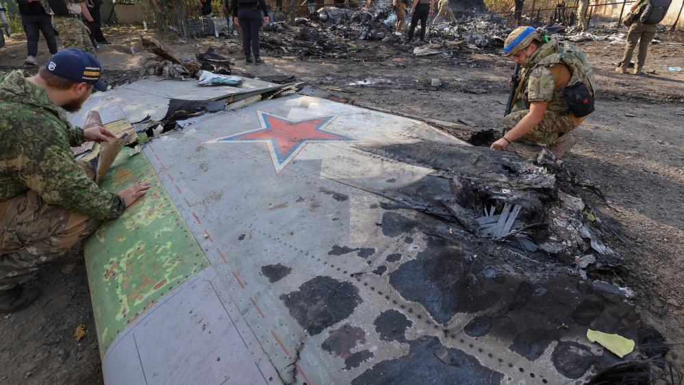 Ukrainian service members inspect parts of a Russian aerial vehicle, which local authorities assume to be a newest heavy unmanned aerial vehicle S-70 Okhotnik (Hunter) or variation of Sukhoi fighting jet, is seen in residential area of the town of Kostintynivka