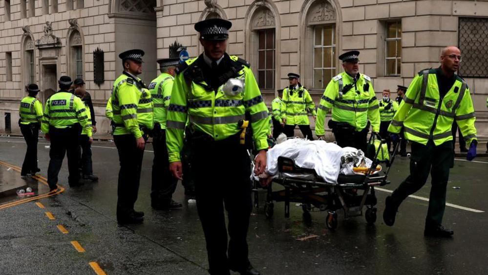Police escorting a patient on a stretcher in Liverpool