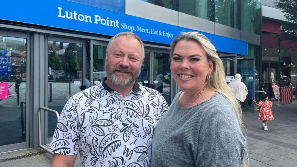 Martin and Barbara Surman standing outside a new sign for Luton Mall