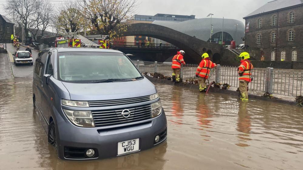 Firefighters pumping water from Sion Street by the River Taff, in Pontypridd, Wales, following flooding on Sunday 24 November.