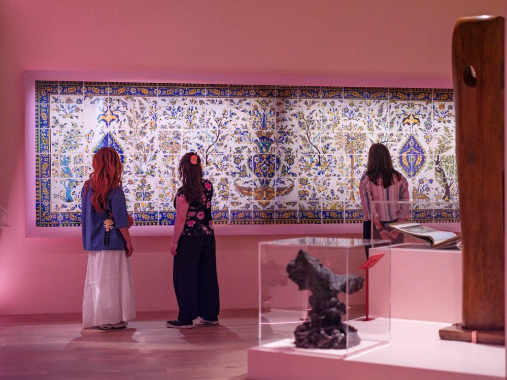 People stand looking at items on display in a gallery