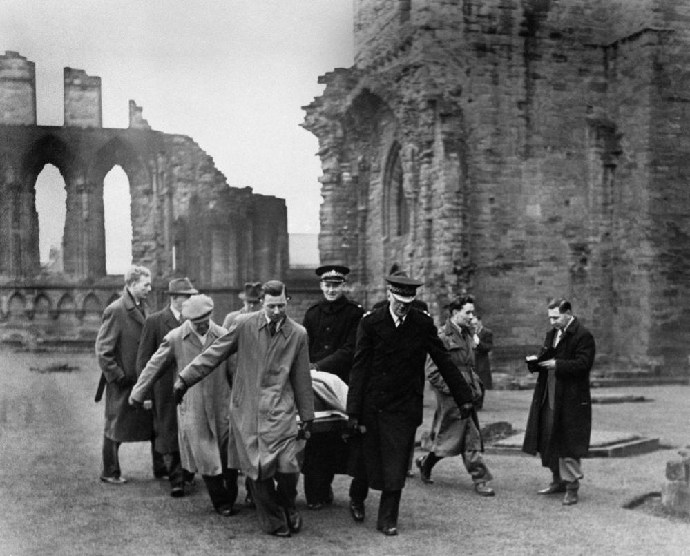 In an old black and white picture from 1951, about seven men carry the Stone of Destiny through the ruins of an abbey.