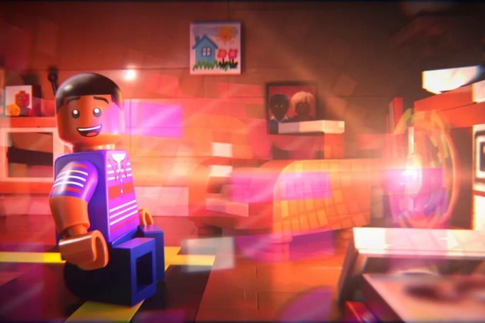 A scene from the movie Piece By Piece, where Pharrell Williams is transported by music coming out of his parent's stereo system. He is a blue Lego figure with short dark hair and is looking animated by lots of coloured lights surrounding him.