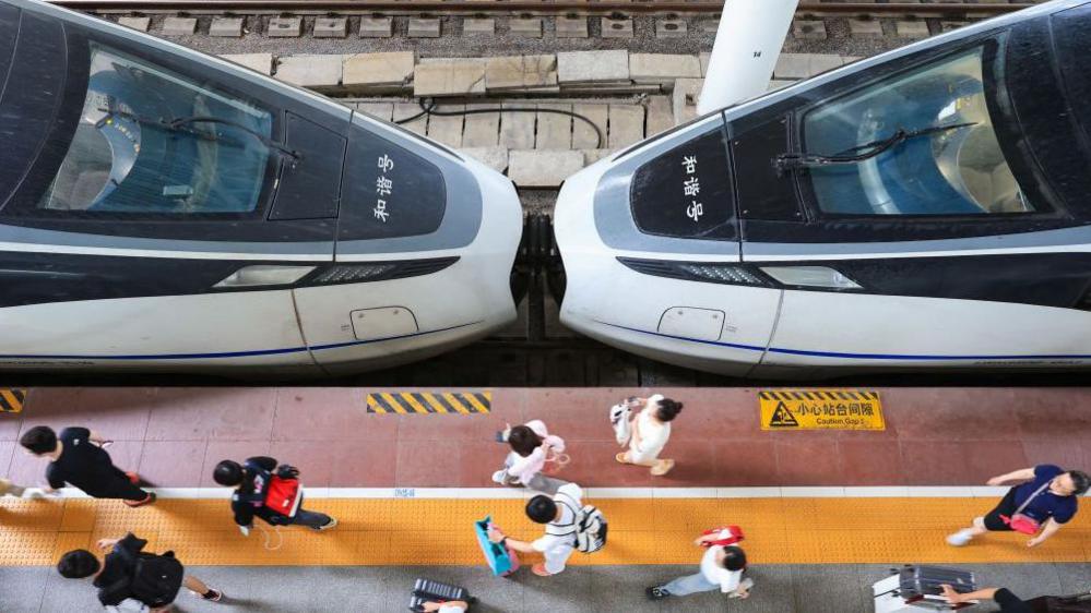 A high-speed rail train at a platform in China, with two power cars joined together