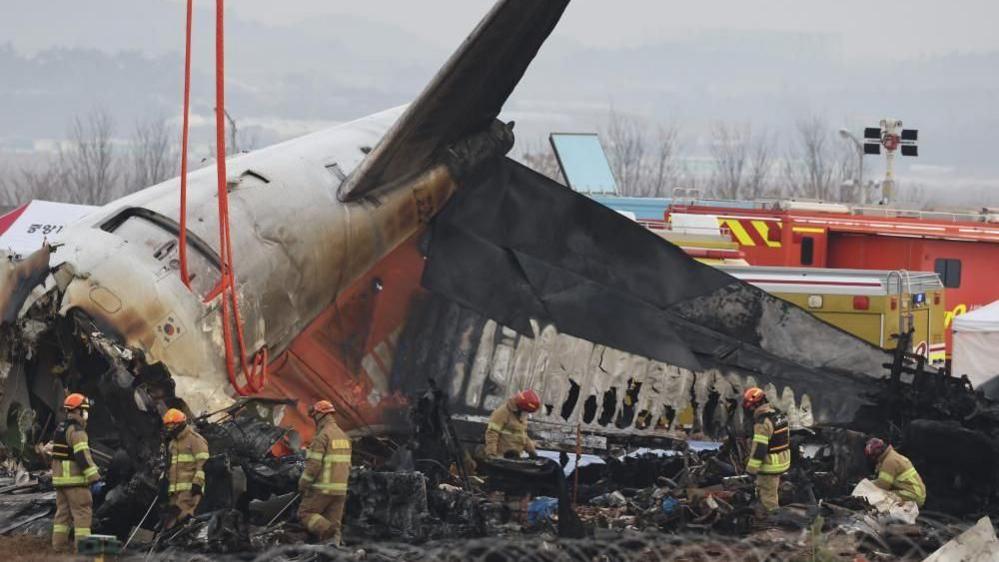 Firefighters conduct search operations at the wreckage site of the Jeju Air aircraft at Muan International Airport in Muan, South Korea, 30 December 2024
