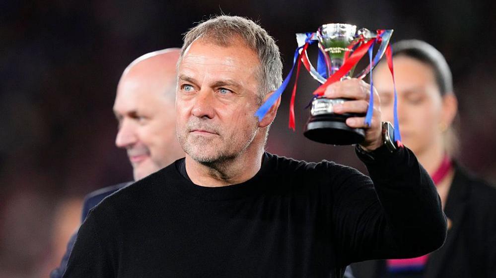Barcelona coach Hansi Flick lifts a trophy