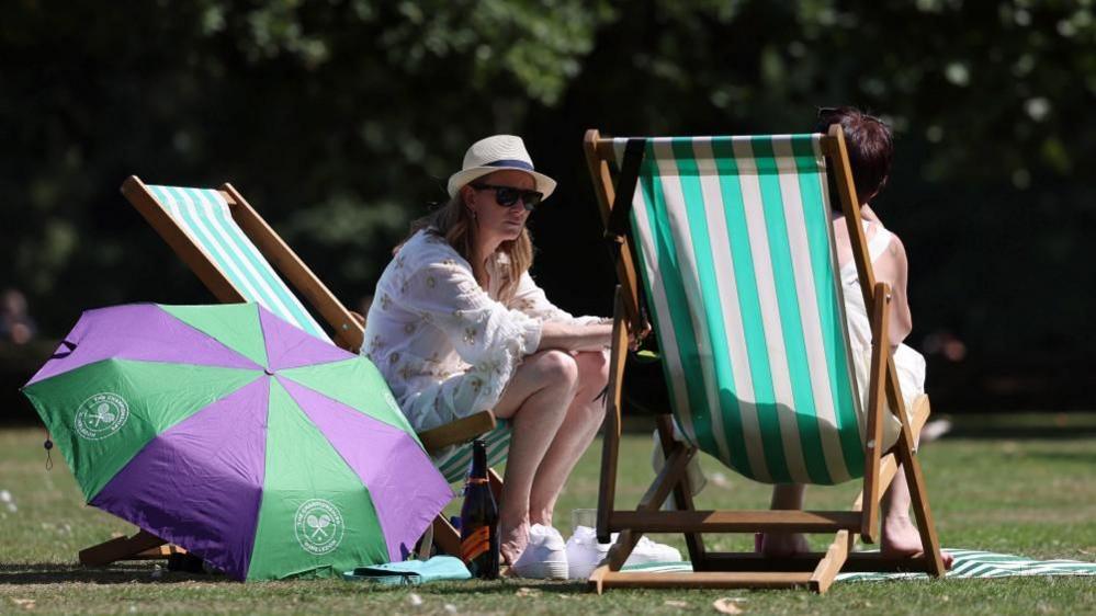 Londoners enjoy the warm weather at a park in London