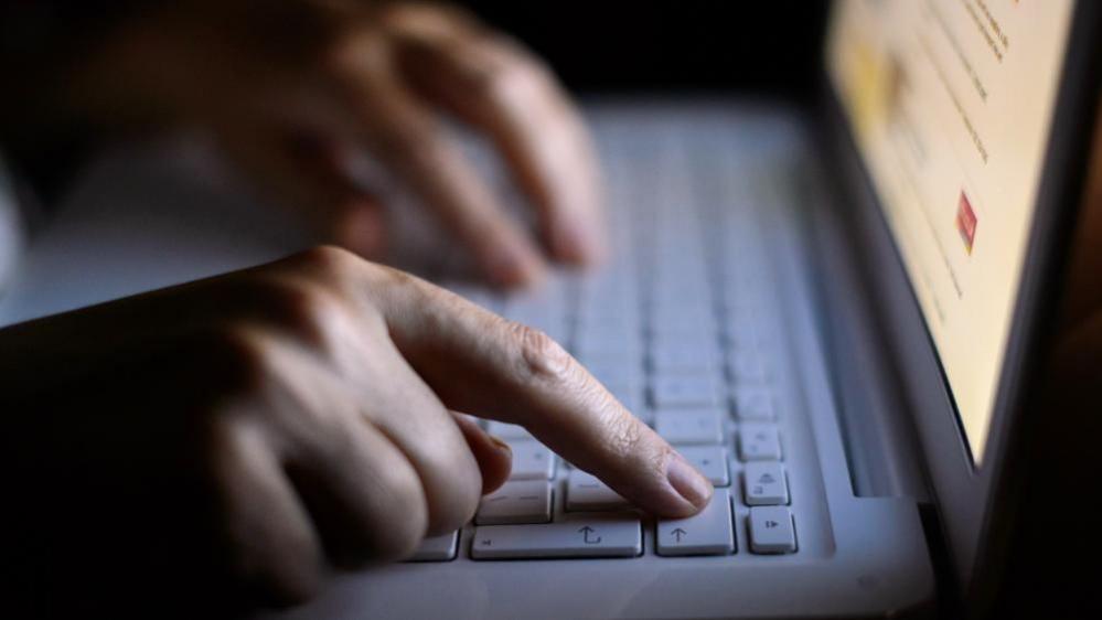 Stock photo of a person's hands on a computer keyboard