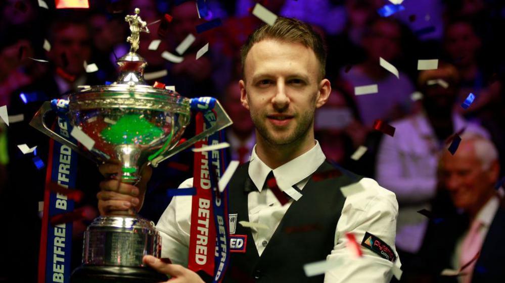 Judd Trump holding the World Championship trophy