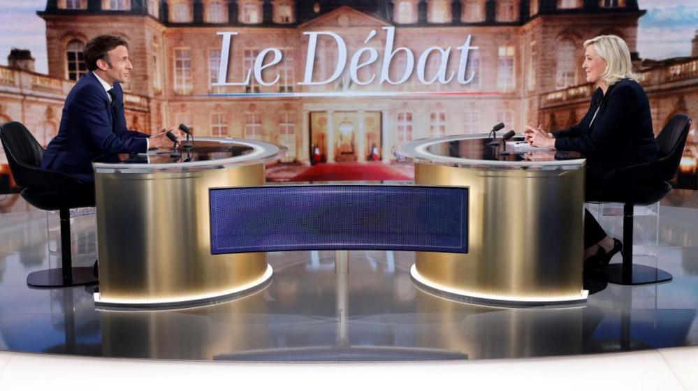 French President and La Republique en Marche (LREM) party candidate for re-election Emmanuel Macron (L) and French far-right party Rassemblement National (RN) presidential candidate Marine Le Pen (R) sit prior to taking part in a live televised debate on French TV channels TF1 and France 2 in Saint-Denis in April 2022