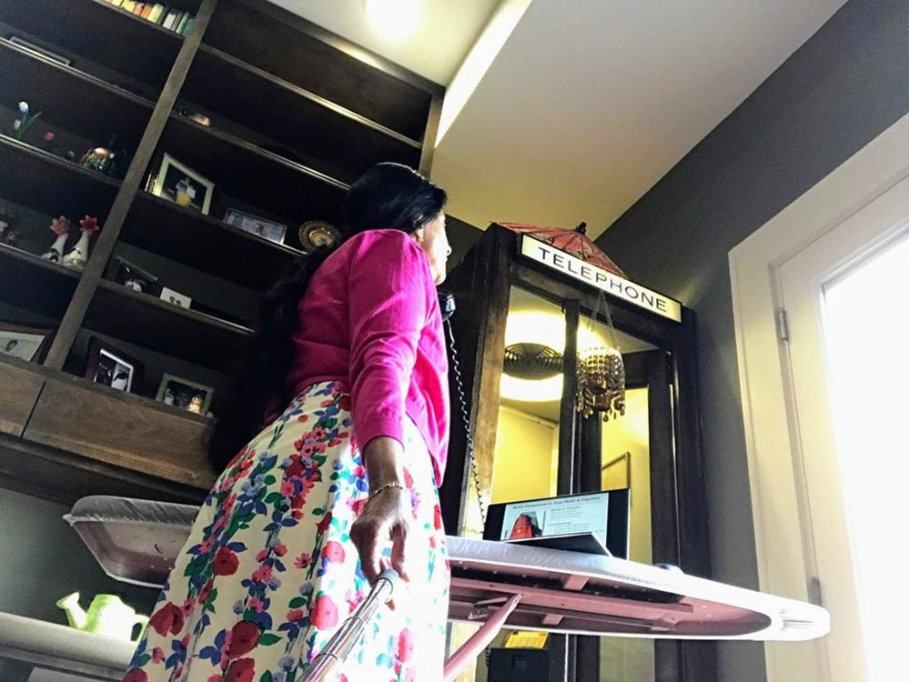 Woman using ironing board as a desk in Indiana, USA