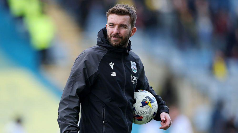 James Morrison is hold a football under his left arm as he takes a training session