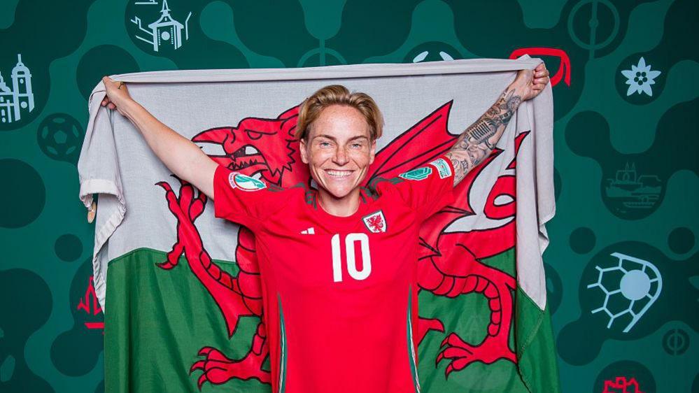 Jess Fishlock holding Wales flag.