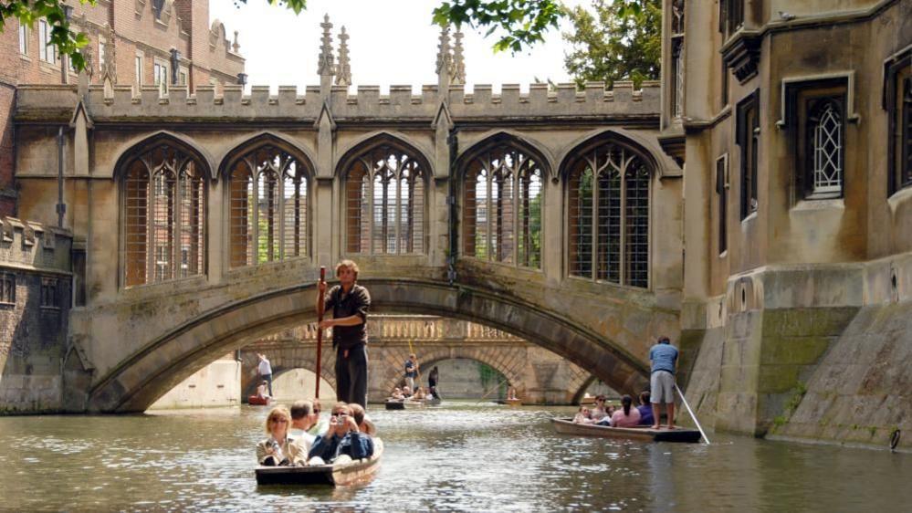 Punts going under river bridges in Cambridge