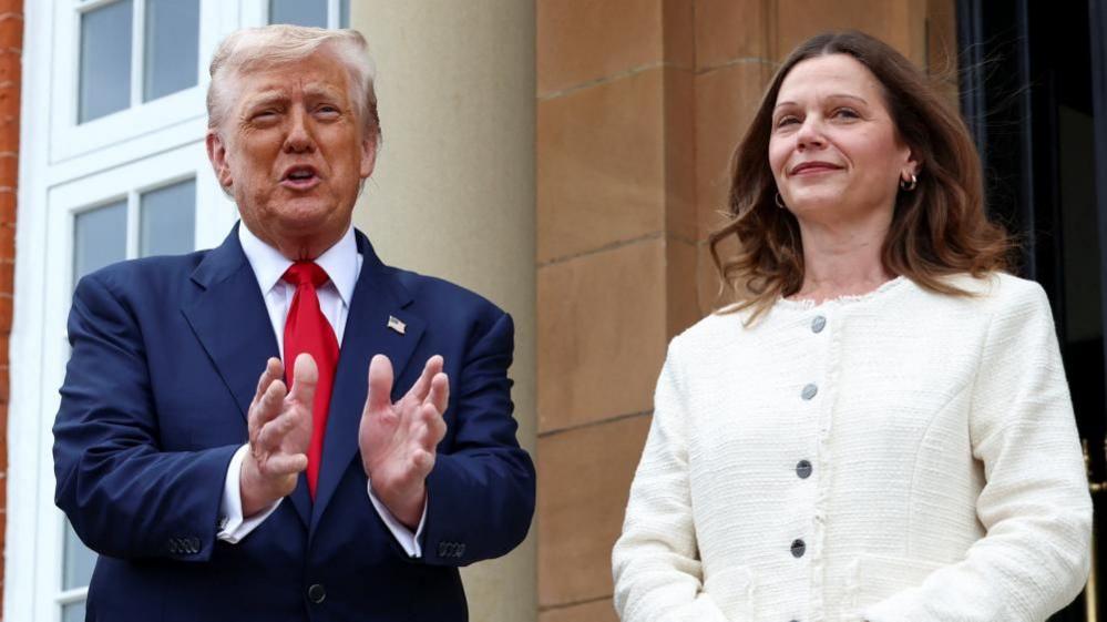Donald Trump, left, stands next to Sir Keir Starmer's wife Victoria as he gestures with both hands
