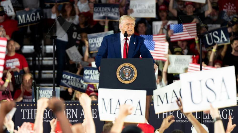 US President Donald Trump speaks at a rally held to celebrate his 100 days in office in Warren, Michigan