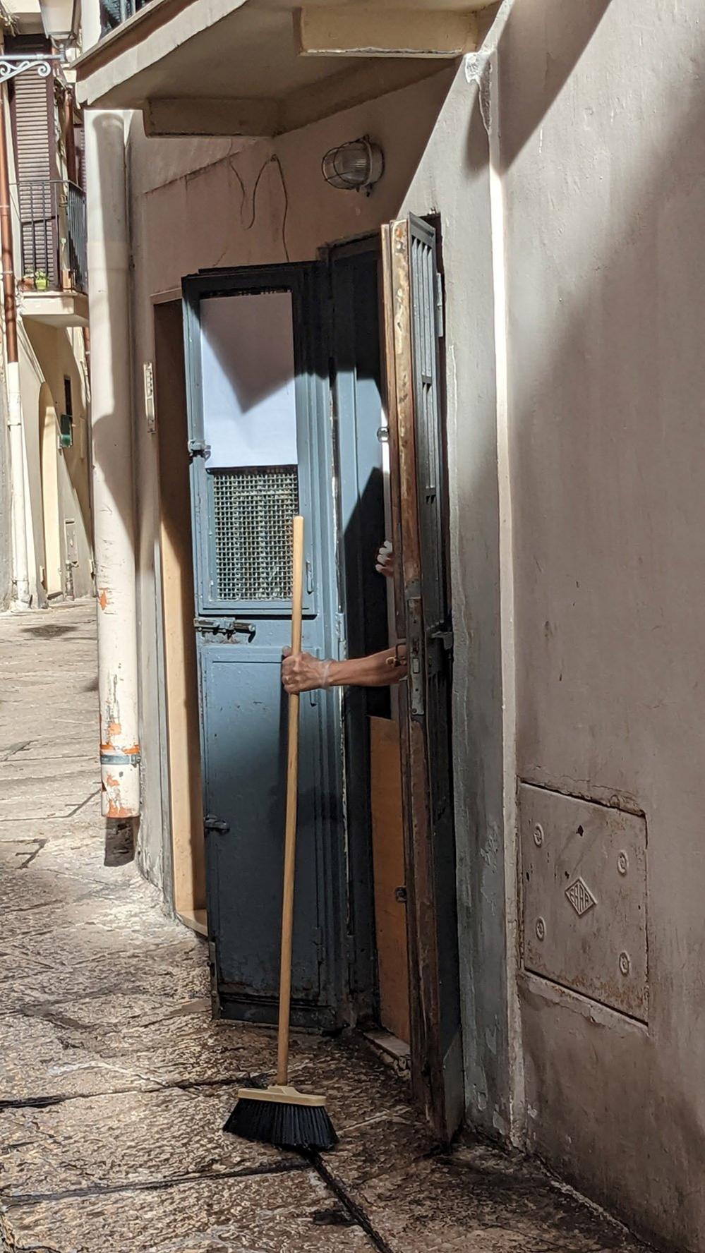 A broom being shaken off outside a door