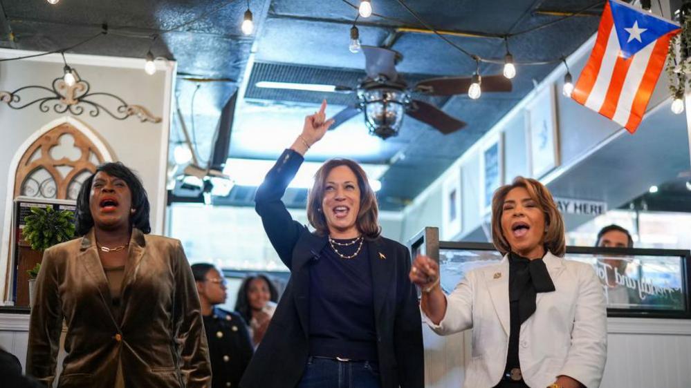 Kamala Harris waving to supporters at a Puerto Rican restaurant in North Philadelphia. 